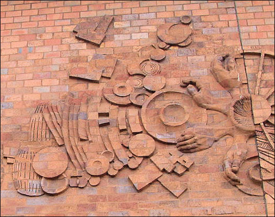 The centre of the relief has a large motif that is formed by half a cartwheel, and a semi-circle of radiating circle of hands.