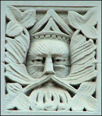 On the first storey façade between shop frontages there are two panels depicting Green-Man type faces,