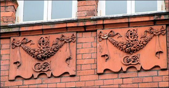 On the upper façade are several identical panels with a garland and the lettering 'O G & Co.'