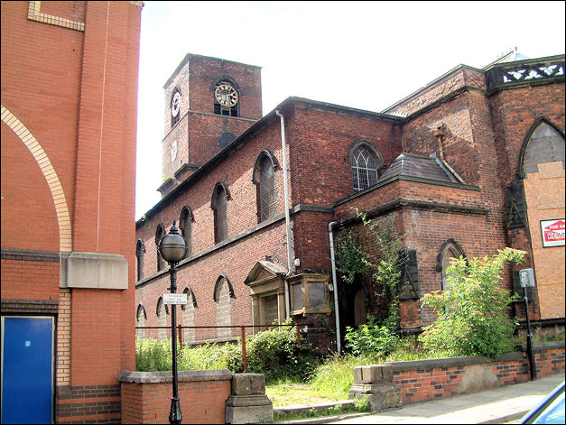 the side of the church - to the left is the corner of The Potteries Shopping Centre