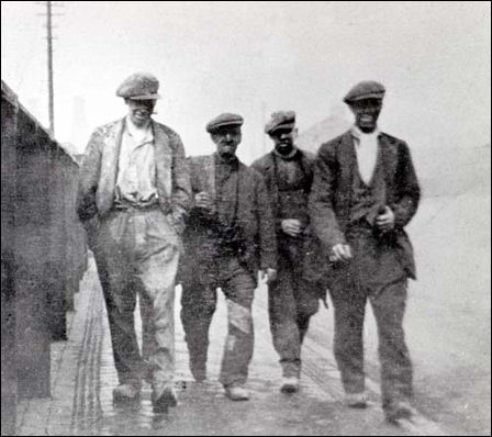 Four colliers walk home, dirty and tired, from a shift at Sneyd Colliery - 1930
