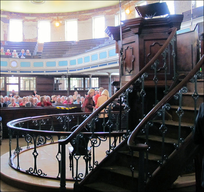 the mahogany pulpit with its double flight of stairs