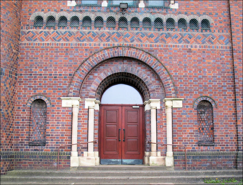 Central wide arched entrance in western gable