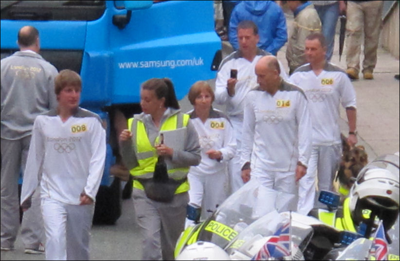 the torch bearers for the later stages make their way to the bus