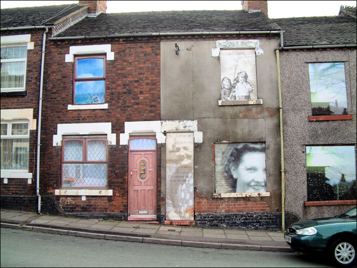 Photographs filling the doors & windows at three houses in Wellington Road, Hanley