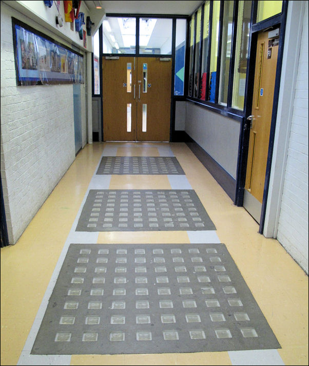 glass blocks in a symetrical pattern inlayed in a corridor floor  