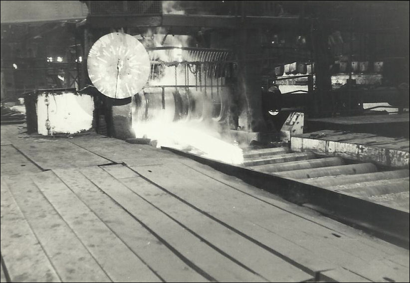 the initial stages of the white hot steel ingots being rolled