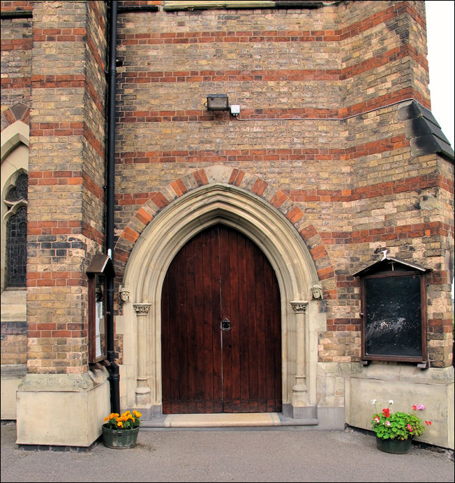 main entrance of the church - built using mainly yellow brick with red brick stripes.