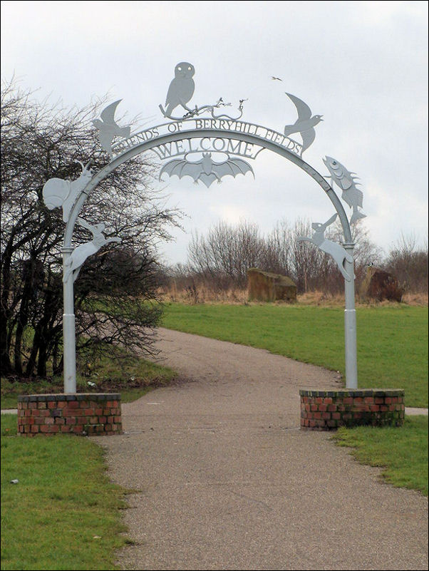 the grey steel archway stands on two circular brick plinths 