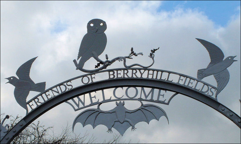 along the top of the arch are two birds either side of an owl a bat hangs from below the archway