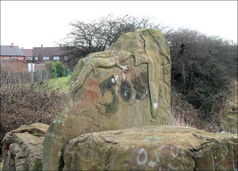 the tallest one is carved with a lizard, a bird and a hunting scene of two men on foot chasing a pair of wild boar