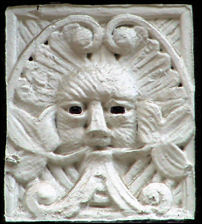 On the first storey faade between shop frontages there are two panels depicting Green-Man type faces,