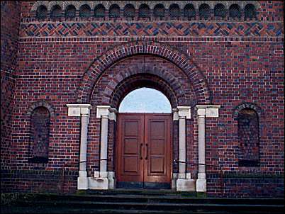 Central wide arched entrance in western gable