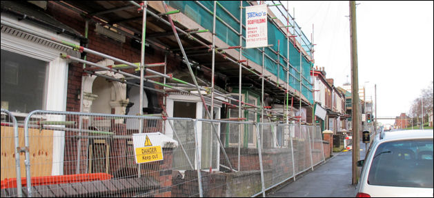 scaffolding around the houses stretching up the road to Hanley 