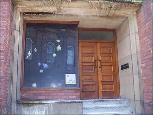 display window of teapots - the old town hall is reflected in the window