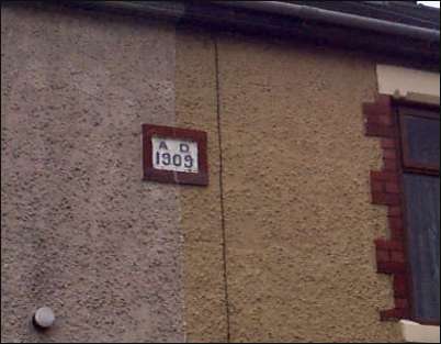 AD 1909 date plaque on the front of the houses above