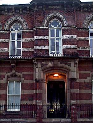 Upper mullioned and transomed windows have quatrefoil tracery in gothic arched heads.