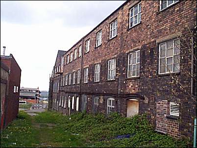 Side of the works - the Potteries Shopping Centre car park is visible at the end of the alleyway.